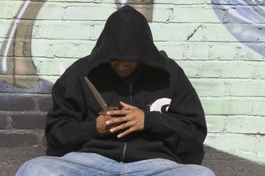 üzerinde siyah ceket elinde bir bıçakla soyguncu