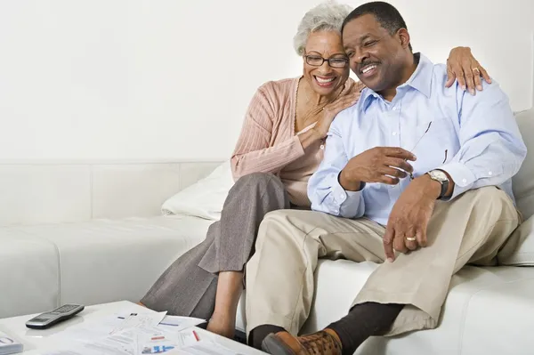 Feliz pareja de ancianos sentado en el sofá — Foto de Stock