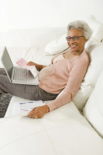 自宅でラップトップを使用して陽気な年配の女性 — ストック写真