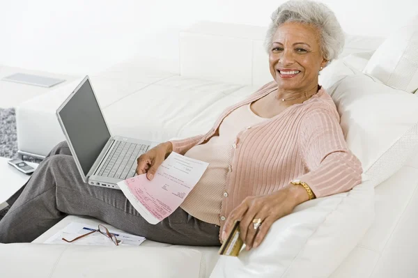 Seniorin bezahlt Rechnungen online — Stockfoto