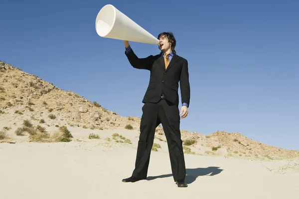 Businessman Using Megaphone in Desert — Stock Photo, Image