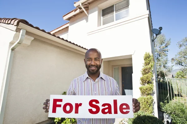 Retrato de um agente imobiliário segurando sinal "Venda" — Fotografia de Stock