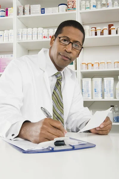 Мужчина-фармацевт, работающий в аптеке — стоковое фото