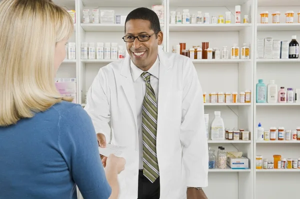 Mujer recogiendo medicamentos recetados en farmacia — Foto de Stock