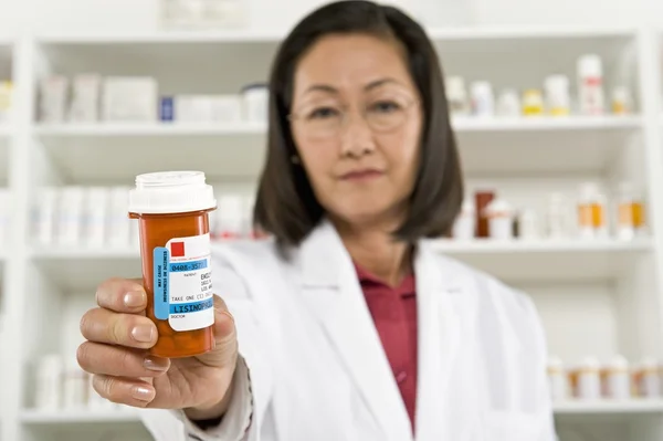 Vrouwelijke apotheker houden van geneesmiddelen op recept — Stockfoto