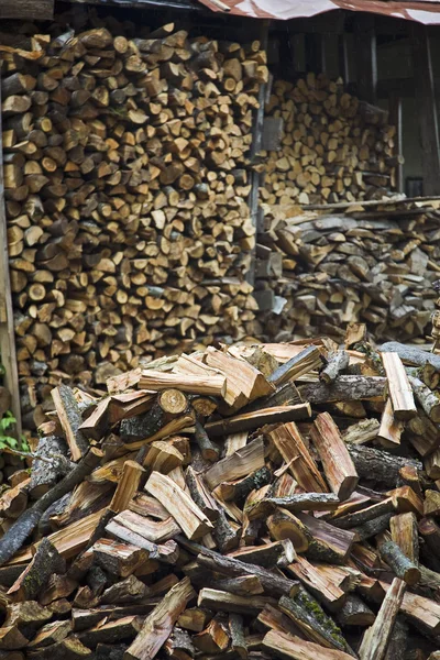 Brennholz mit Holzschuppen im Hintergrund — Stockfoto