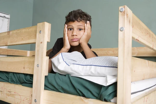 Cansado multi menino étnico deitado na cama — Fotografia de Stock