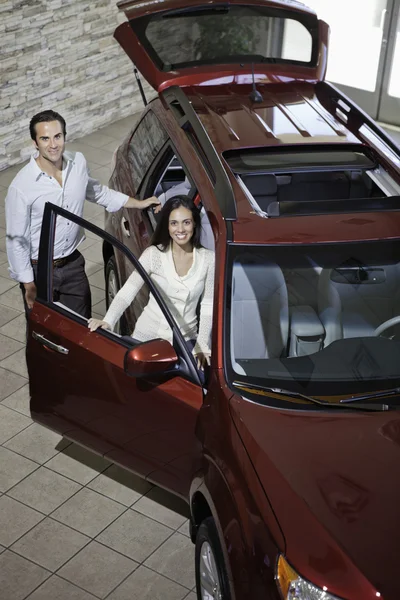 Happy couple in luxury car show room — Stock Photo, Image