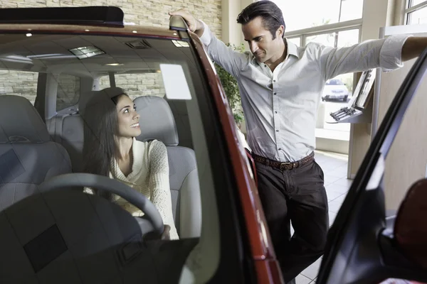 Couple talking in car show room — Stock Photo, Image