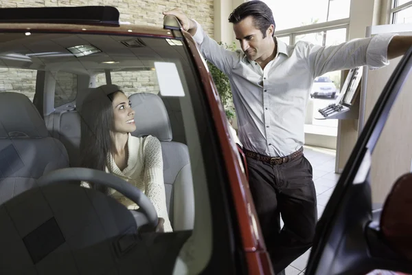 Pareja hablando en la sala de exposiciones de coches —  Fotos de Stock