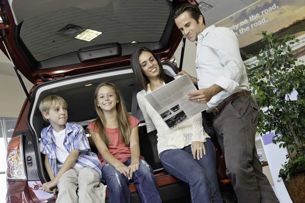 Låg vinkel syn på familjen som sitter på baksidan av bilen — Stockfoto