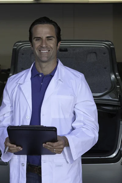 Porträt eines lächelnden Autoverkäufers mit Klemmbrett — Stockfoto
