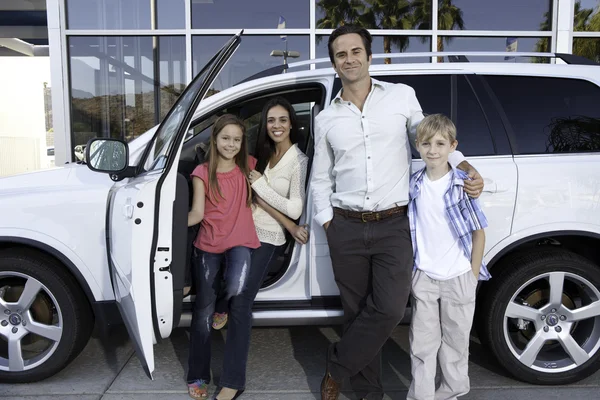 Gelukkige familie naast witte auto — Stockfoto
