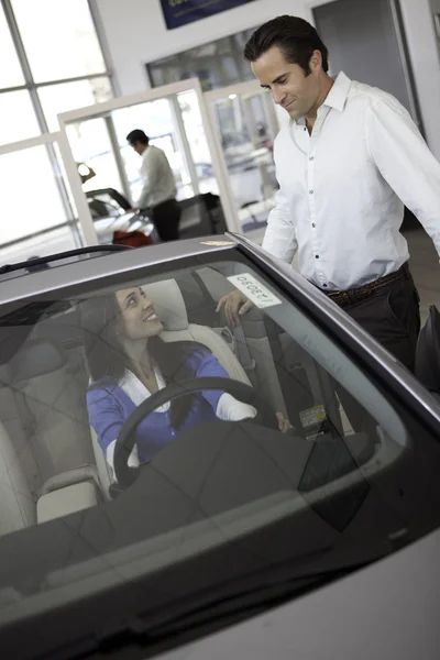 Женщина сидит в машине с мужем, стоящим рядом с машиной — стоковое фото