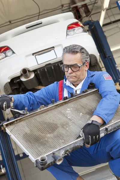 Mécanicien travaillant sur une pièce automobile d'une voiture avec une clé — Photo