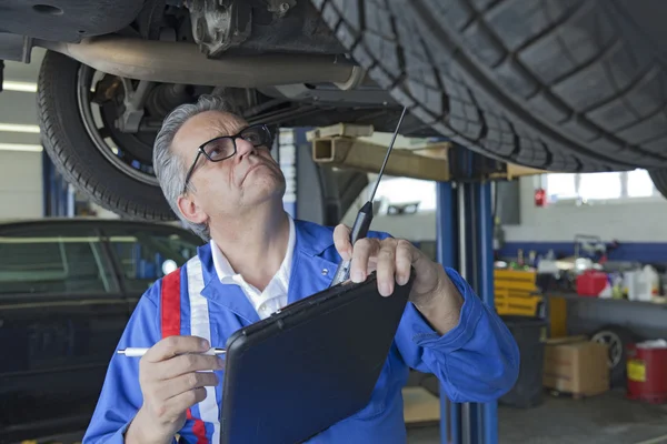 Mekaniker analysera bilmotor på auto reparera butik — Stockfoto
