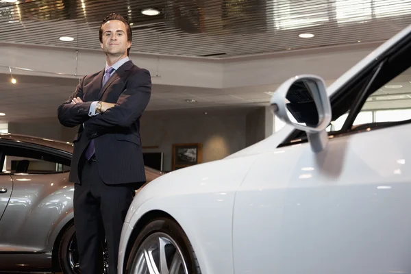 Confident car salesperson standing with arms crossed — Stock Photo, Image