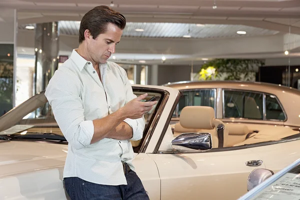 Hombre de pie junto al coche con su teléfono móvil —  Fotos de Stock