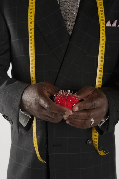 Mid section of man wearing suit holding pincushion — Stock Photo, Image