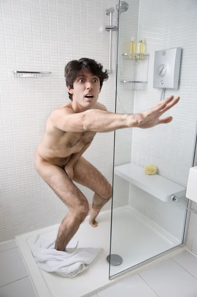 Scared naked man stopping someone in bathroom — Stock Photo, Image
