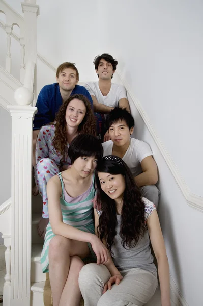 Group portrait of young friends sitting in stairway — Stock Photo, Image