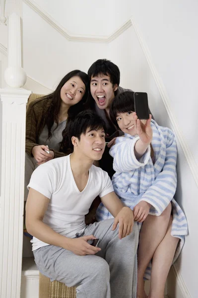 Young couples taking self portrait photographs on stairway — Stock Photo, Image