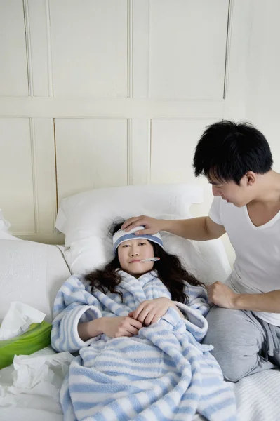 Young man taking care of sick woman in bed — Stock Photo, Image