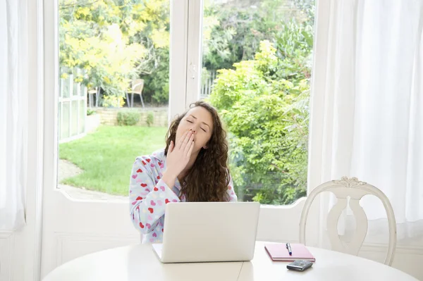 Jovem exaustão sentada na frente do laptop — Fotografia de Stock