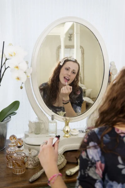 Jovem mulher aplicando batom — Fotografia de Stock