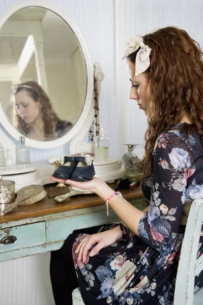 Jonge vrouw met baby slofjes — Stockfoto