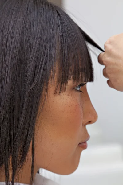 Vista lateral de la mujer asiática conseguir un nuevo corte de pelo — Foto de Stock