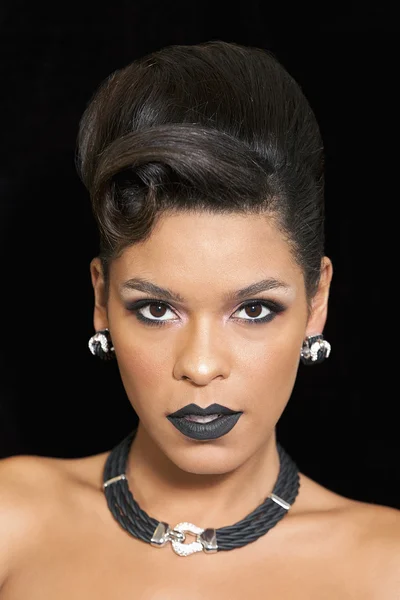 Gorgeous woman with black lipstick posing against black background — Stock Photo, Image