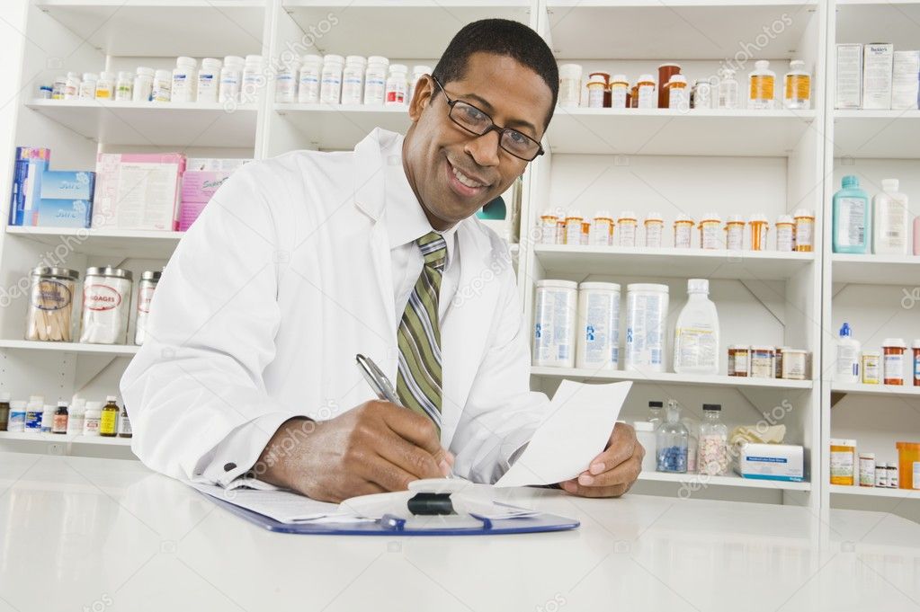 Male Pharmacist Working In Pharmacy
