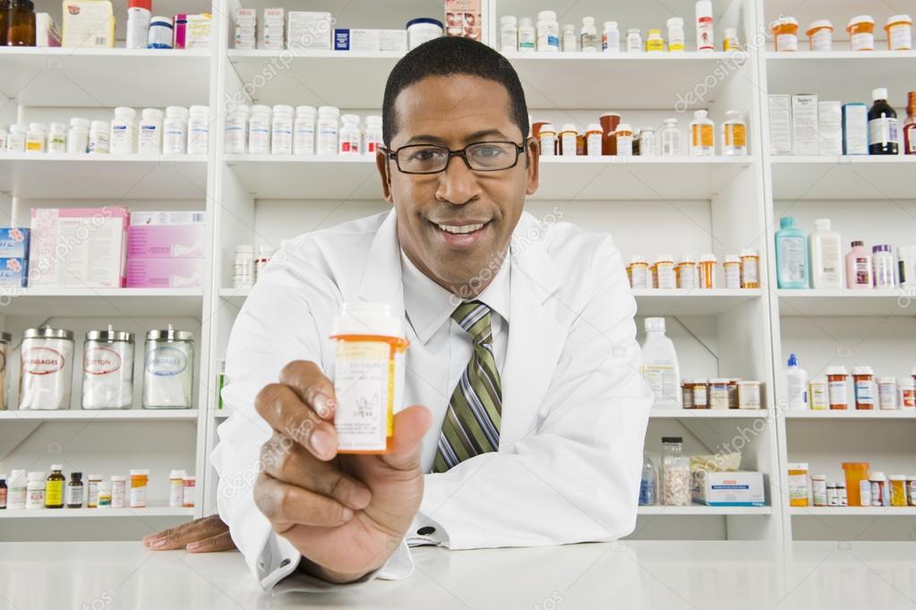 Male Pharmacist Working In Pharmacy