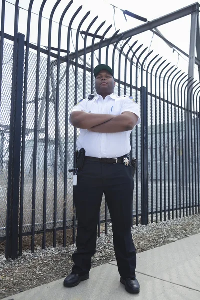 Gardien debout devant la clôture de la prison — Photo