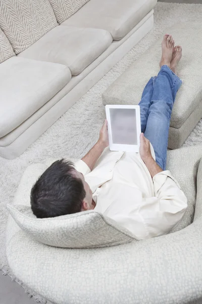 Расслабленный человек, держащий цифровой планшет — стоковое фото