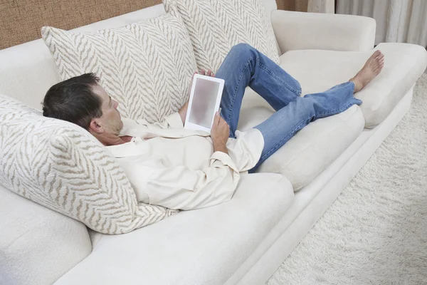 Zrelaksowany człowiek za pomocą cyfrowego tabletu — Zdjęcie stockowe