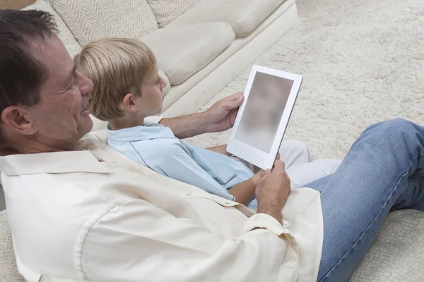 Padre e figlio guardando la tavoletta digitale — Foto Stock