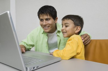 Father and Son Using Laptop clipart