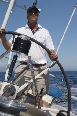 Man Steering a yacht clipart
