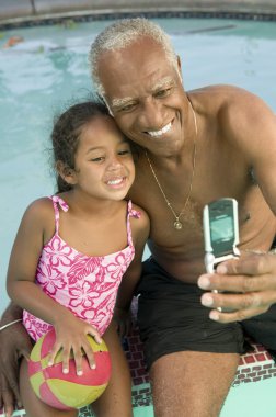 Grandfather and Granddaugther Posing for Camera Phone clipart