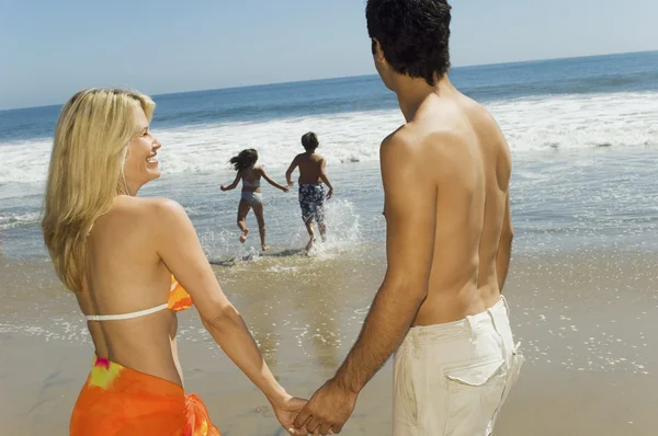 Parents Watching Kids Running Toward Water — Stock Photo, Image