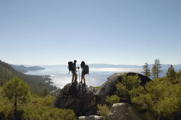 Couple standing on rock at coast — Stock Photo, Image