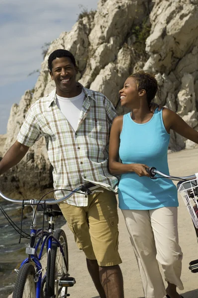 Couple walking with bicycles — Stock Photo, Image