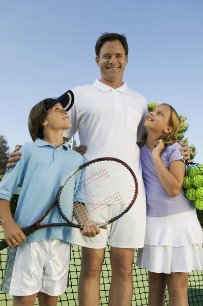 Père avec enfants sur le court de tennis — Photo