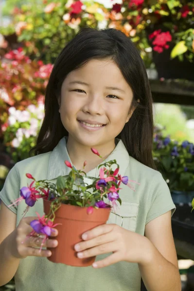 Ung flicka håller krukväxter blommor — Stockfoto