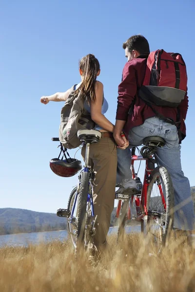 Couple with mountain bikes by the lake — Stock Photo, Image