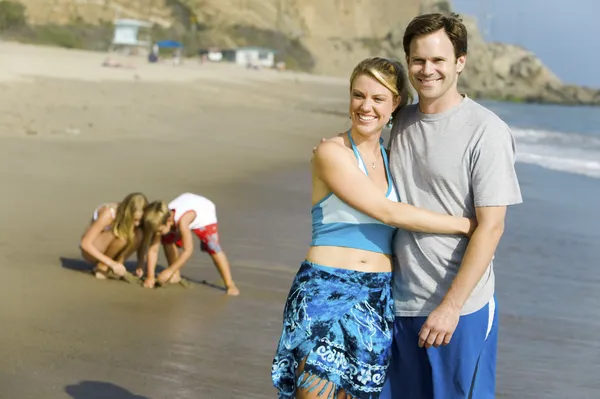 Paar mit Familie genießt Strand — Stockfoto