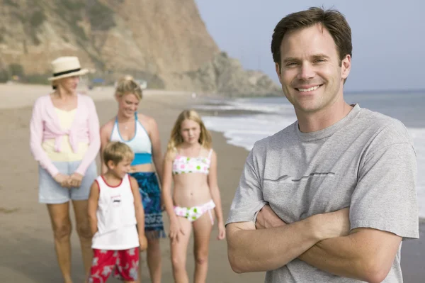 Человек на пляже с семьей — стоковое фото