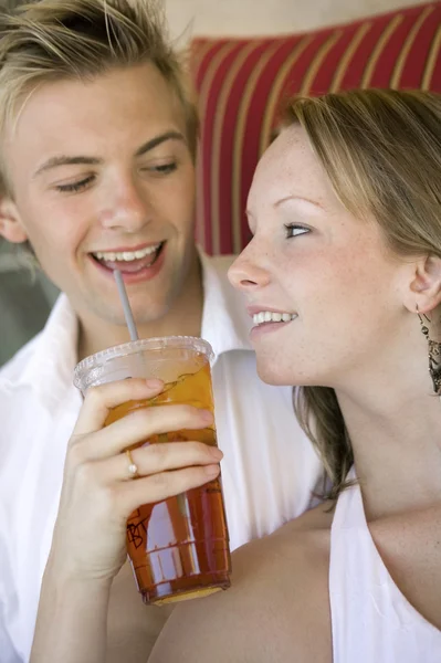 Paar delen drankje aan het zwembad — Stockfoto